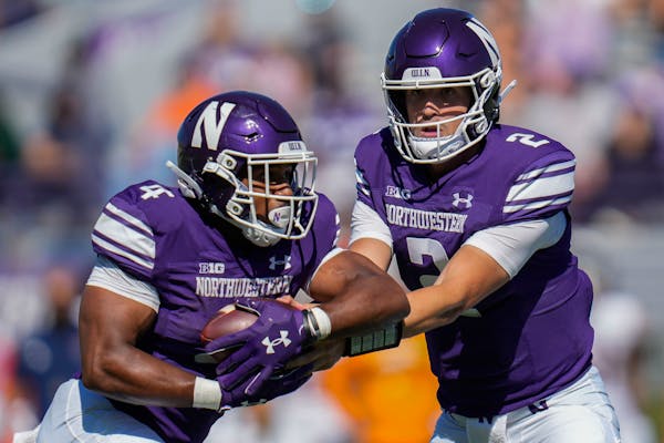 Northwestern quarterback Ben Bryant, right, handed off to running back Cam Porter in the team’s 38-7 victory against UTEP on Sept. 9.