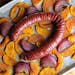Glazed hasselback kielbasa, roasted with squash and red onions, is a tasty one-dish dinner.