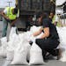 Nicole Torres, a spokeswoman for the Office of Emergency Management for the city of Annapolis, Md., ties a sandbag on Friday, Sept. 22, 2022 as reside