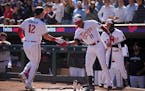 Minnesota Twins shortstop Kyle Farmer (12) celebrates at home with Minnesota Twins designated hitter Jorge Polanco (11) after hitting a home run in th