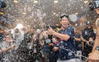 Minnesota Twins starting pitcher Kenta Maeda (18) and other Twins players celebrate with champagne in the locker room after clentched the American Lea