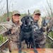 Sophie Arhart, left, with her sister Gracie and Ace the black Labrador in southern Minnesota during Saturday’s duck opener. Two woodies, a pintail a