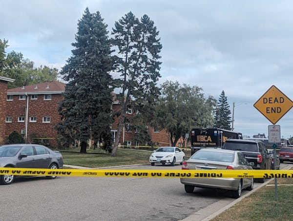 Police tape marked off the Roseville apartment building where police officers found three men dead and a fourth badly injured early Saturday.