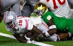 Ohio State running back Chip Trayanum (19) scores as Notre Dame safety DJ Brown (2) tries to stop him with one second left. Notre dame only had 10 men