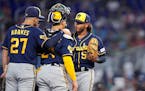 Brewers starting pitcher Freddy Peralta, right, talked with shortstop Willy Adames (27) and catcher William Contreras, center, after the Marlins loade