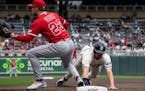 Twins first baseman Alex Kirilloff (19) slid safely back to first base against Angels first baseman Brandon Drury (23) in the second inning Sunday at 