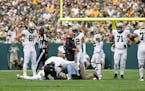 Saints quarterback Derek Carr (4) was tended to during the second half against the Packers on Sunday.