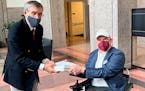 Dan Tate, right, delivers a printed petition from ALS patients and advocates to Dr. Peter Marks, left, director of the Food and Drug Administration’