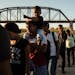 Migrants make their way toward law enforcement personnel to surrender and begin their immigration process, in Eagle Pass, Texas on Sept. 23, 2023. Des