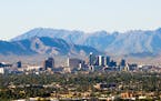 Downtown Phoenix skyline with the South and Sierra Estrella mountain ranges in the background. 