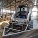 Carey Tweten drives a tractor through the barn to push feed to the cows Wednesday, June 15, 2023, at Valley Acres Dairy in Lewiston, Minn. 