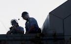 A Minneapolis police officer fires a rubber bullet from atop the Minneapolis Police third precinct station on E. Lake St. during a third night of unre