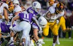 Minnesota running back Darius Taylor, right, fights his way into the end zone for a touchdown against Northwestern during the first half of an NCAA co