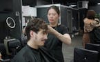 Josh Bonde, 23, checked out the results of his perm in the mirror while stylist Trang Nguyen gave him a post-perm trim. 