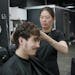 Josh Bonde, 23, checked out the results of his perm in the mirror while stylist Trang Nguyen gave him a post-perm trim. 
