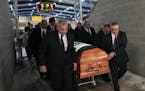 Pallbearers carried the casket of Henry Boucha out of the Gardens Arena, where his number 16 hangs from the rafters, following his funeral services Fr