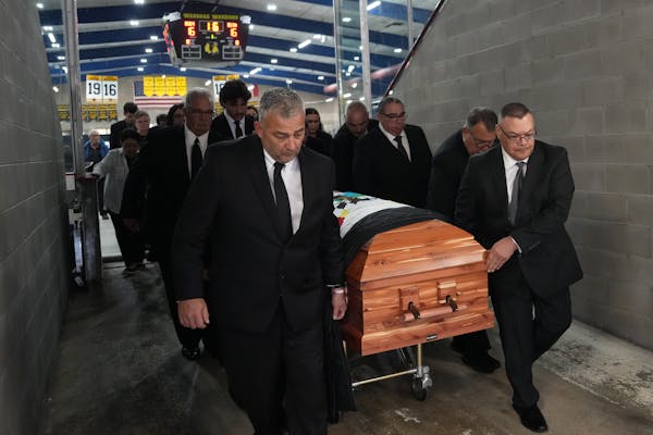 Pallbearers carried the casket of Henry Boucha out of the Gardens Arena, where his number 16 hangs from the rafters, following his funeral services Fr