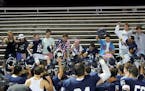 Fans who remained after a long weather delay got personal attention from St. Thomas Academy’s players during the victory celebration.