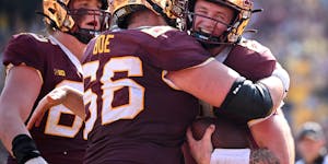 Gophers quarterback Athan Kaliakmanis (8) celebrated with offensive lineman Nathan Boe (66) after Kaliakmanis scored a second-quarter touchdown agains