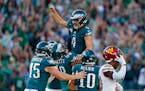 Eagles kicker Jake Elliott (4) was lifted by tackle Jordan Mailata (68) after kicking the winning field goal in overtime to beat the Commanders.