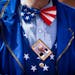 A supporter of former President Donald Trump, a Republican presidential candidate, dressed as Uncle Sam with a wanted poster pin as Trump delivers rem
