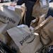 Amazon Prime Now bags full of groceries are loaded for delivery by a part-time worker outside a Whole Foods store in 2018, in Cincinnati.