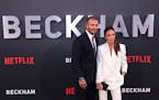 David Beckham, left, and Victoria Beckham pose for photographers upon arrival at the premiere of the television program “Beckham” on Tuesday, Oct.