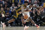 The Wolves’ Anthony Edwards, right, stretched to try to strip the ball from the Warriors’ Andrew Wiggins during the first half Sunday night.