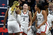 UConn guard Paige Bueckers (5) celebrated with teammates Aaliyah Edwards (3) and Ice Brady (25) during an 80-48 home victory over Maryland on Thursday