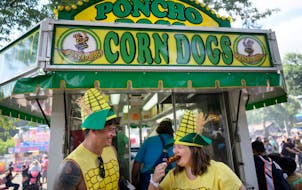 Friends Danny Suelter, left, and Katelyn Christensen of Minneapolis made a stop at Poncho Dog’s Corn Dogs stand in 2022. 