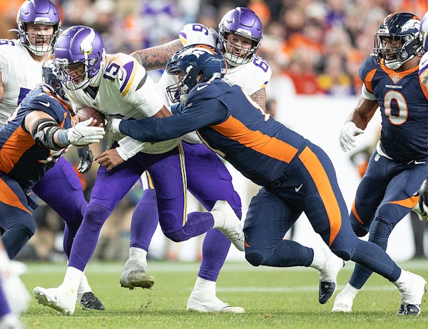 Vikings quarterback Joshua Dobbs (15) is sacked by Broncos defensive end Matt Henningsen (91), left, and Broncos defensive end Zach Allen (99) in the 