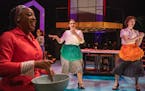 Lynnea Doublette walks by as Camryn Buelow and Olivia Kemp dance in the Hamburger Helper scene of History Theatre’s “I am Betty.”