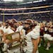 Stewartville players and cheerleaders gathered in front of their fans with the Class 3A trophy Saturday at U.S. Bank Stadium.