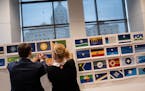 Jack Barrett and Anita Gaul of the State Emblems Redesign Commission hang up some of the 216 flag designs that made the first cut from the original 21