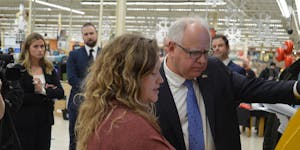 Gov. Tim Walz, right, learned how to get vehicle tabs renewed at a kiosk inside a Cub Foods in Rochester on Tuesday afternoon.