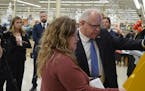 Gov. Tim Walz, right, was shown how to get vehicle tabs renewed at a kiosk inside a Cub Foods in Rochester on Tuesday afternoon, Nov. 28, 2023.
