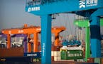 A crane lifts a shipping container at an automated container port in Tianjin, China, Jan. 16, 2023.