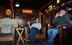 Friends Joe Blauert, left, of St. Paul, and Scott Johnson of Carver enjoy cigars in the smoking lounge at Anthony’s Pipe and Cigar Lounge in south M