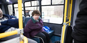 Lolly Lijewski, who uses a seeing eye dog named Jiffy for vision impairment, settled into a Metro Mobility bus after being picked up outside her home 