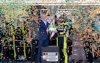 Ryan Blaney, center right, received the Cup Series Championship Cup from NASCAR President Steve Phelps after winning it at Phoenix Raceway on Nov. 5.