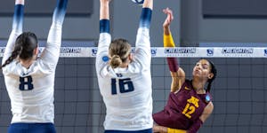Minnesota’s Taylor Landfair hit between Utah State’s Kelsey Watson (8) and Adna Mehmedovic (16) during Friday’s NCAA women’s volleyball tourna