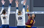 Minnesota’s Taylor Landfair hit between Utah State’s Kelsey Watson (8) and Adna Mehmedovic (16) during Friday’s NCAA women’s volleyball tourna