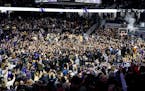 Northwestern players celebrate with fans after the Wildcats defeated No. 1 Purdue 92-88 in overtime 