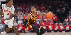 Gophers guard Elijah Hawkins (0) worked his way past Ohio State’s Dale Bonner (4) on Sunday in Columbus, Ohio.
