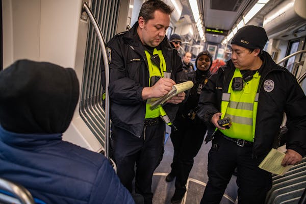 Community service officers Aaron Hardin and Kang Vang checked fares Monday, Dec. 4, on the Green Line in St. Paul.