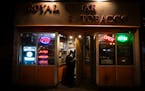 Royal Cigar & Tobacco customers walk into the Dinkytown store the night after two people were shot and killed in Minneapolis, Minn. on Sunday, Dec. 3,
