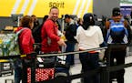 Travelers wait to check luggage into their Spirit Airlines at George Bush Intercontinental Airport, Tuesday, Nov. 21, 2023, in Houston.